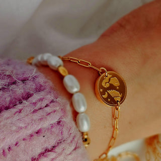 12 Constellation Zodiac sign charms 
Adjustable paperclip chain bracelets in 18k gold tarnishfree surgical grade stainless steel 316L. Double sided engraved with cubic zirconia etched gemsas a part of Constellationdesign to one side and your Zodiacto the other side of the disc coin charm.