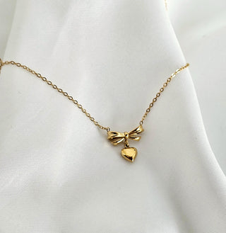 3 dimensional bow detailed charm along with a dangle drop heart charm pendant on a dainty thin gold chain tarnishfree 18k gold plated on stainless steelwaterptoof jewellery