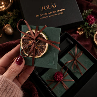 Hand holding the first ZOLÁI Advent Sunday box above the open box